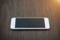 Smart phone with blank screen lying on wooden table Royalty Free Stock Photo