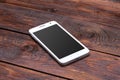 Smart phone with blank screen lying on wooden Royalty Free Stock Photo