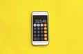 Smart phone with calculator on yellow background. Royalty Free Stock Photo
