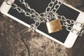 Smart phone with chain padlock on wooden table, mobile safety security concept Royalty Free Stock Photo