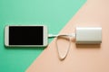 Smart phone charging with power bank on paper background. Recharging concept. Royalty Free Stock Photo