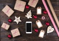 Smart phone with christmas presents on wooden background top view. Online holiday shopping concept. Flat lay, text space. Internet Royalty Free Stock Photo