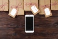 Smart phone with christmas presents on wooden background top view. Online holiday shopping concept. Flat lay, text space. Internet Royalty Free Stock Photo