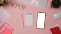 Smart phone, coffee cup, glasses and notebook on pink background. Female workspace Royalty Free Stock Photo