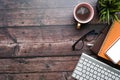 Smart phone, coffee cup, notebook, glasses, keyboard on wooden desk. Royalty Free Stock Photo