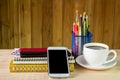 Smart phone,coffee cup,and stack of book with calendar on wooden Royalty Free Stock Photo