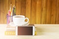 Smart phone,coffee cup,and stack of book on wooden table background. Royalty Free Stock Photo