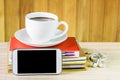 Smart phone,coffee cup,and stack of book on wooden table Royalty Free Stock Photo
