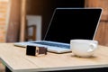 Smart phone and cup of coffee and laptop on woden desk. Royalty Free Stock Photo