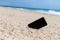 Smart phone with empty screen on tropical sand beach background Royalty Free Stock Photo