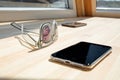 A smart phone with glasses, coffee, on the wood desk Royalty Free Stock Photo