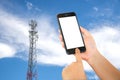 Smart phone in hand with mobile towers background.