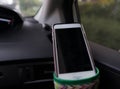 Smart phone hang on cup holder inside car front selective focus Royalty Free Stock Photo