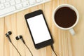 Smart phone with headphones, keyboard and coffee cup Royalty Free Stock Photo