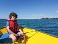 Kid fishing from small dinghy on Tauranga Harbour.