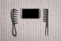 Smart phone between hairbrushes Royalty Free Stock Photo