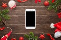 Smart phone mockup surrounded with Christmas decorations on wooden table Royalty Free Stock Photo