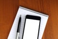 Smart phone, pen and notepad Royalty Free Stock Photo