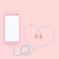 Smart phone pink color and earphones pink color heart shape Royalty Free Stock Photo