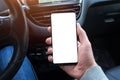 Smart phone with screen for mockup in car driver hand. Close up