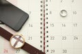 Smart phone,watch and silver ring put on desktop calendar