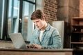 Smart pleasant man looking at the laptop screen