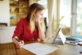 Smart schoolgirl doing her homework with digital tablet at home. Child using gadgets to study. Education and learning for kids. Royalty Free Stock Photo