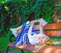 Smart and pretty. Smart lady relaxing. Girl lay bench park relaxing with book, green nature background. Woman spend Royalty Free Stock Photo