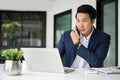 Smart Asian businessman is talking on the phone with his client at his desk Royalty Free Stock Photo