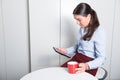 Smart professonal woman is looking on tablet during coffee break