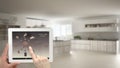 Smart remote home control system on a digital tablet. Device with app icons. Blurry interior of minimalist kitchen in the backgrou Royalty Free Stock Photo