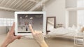 Smart remote home control system on a digital tablet. Device with app icons. Scandinavian loft open space with bedroom and bathroo