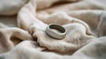 Silver smart ring resting on a textured beige fabric in soft natural light studio Royalty Free Stock Photo