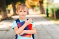 Smart schoolboy holding books outdoors. Education and elementary school. Little student with schoolbag Royalty Free Stock Photo