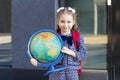 Smart schoolchild with red schoolbag holding globe in hands. Education Royalty Free Stock Photo