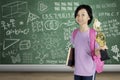 Smart schoolgirl carrying a book and trophy