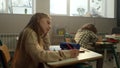 Smart schoolgirl writing in notebook at lesson in elementary school Royalty Free Stock Photo