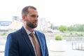 A smart, serious, confident man in a business suit against a blurry urban landscape. Portrait of a middle-aged Royalty Free Stock Photo