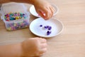 small child, toddler counts, sorts small plastic chips color, kid's fingers closeup, development fine motor skills, tactile Royalty Free Stock Photo