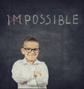 Smart smiling boy standing in front of blackboard Royalty Free Stock Photo