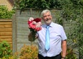 Smart smiling man giving bunch of flowers.