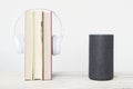 Smart speaker Amazon Alexa Echo device next to some books and hearphones against a white background. Empty copy space