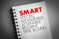 SMART - Specific, Measurable, Attainable, Relevant, Time bound acronym on notepad, business concept background