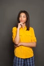 Smart student black woman brunette thinking ans standing against gray background. Brainstorming concept Royalty Free Stock Photo