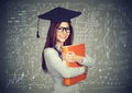 Smart student with graduation cap over math science formulas blackboard Royalty Free Stock Photo