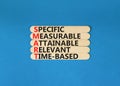 SMART symbol. Concept words SMART specific measurable attainable relevant time-based on stick. Beautiful blue background. Business