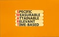 SMART symbol. Concept words SMART specific measurable attainable relevant time-based on stick. Beautiful orange background.