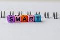 SMART text on colorful plastic beads representing Specific, Measurable, Achievable, Relevant and Time Bound with notepad