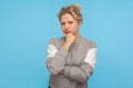 Smart and thoughtful girl with short curly hair in sweatshirt holding her chin and pondering idea, making difficult decision Royalty Free Stock Photo