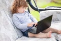 Smart toddler girl using laptop computer, child and technology. Royalty Free Stock Photo